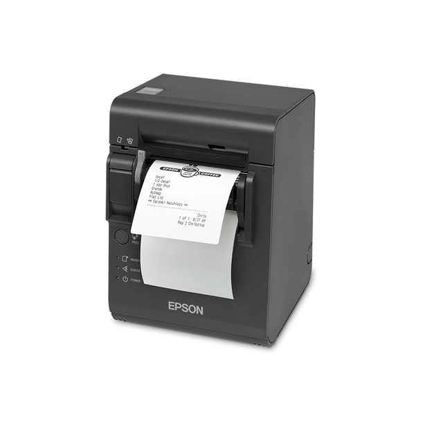 A high-angle, front-facing three-quarter view of a dark gray Epson TM-L90 Plus linerless thermal printer on a crisp white background. A white adhesive order ticket with a printed coffee shop logo and a drink order list feeds out from the front delivery slot. The printer features a prominent white Epson logo on the lower front, with a circular feed button and small labeled indicator lights for paper, error, and power aligned on the bottom left.