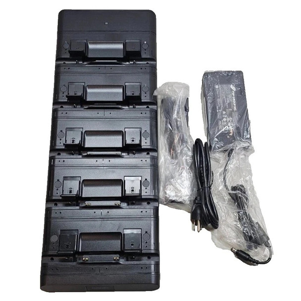 Top-down view of a black NCR 5-slot tablet charging docking station kit, arranged vertically next to its bundled power supply unit, wrapped AC power cable, and DC connector cord in clear protective plastic packaging against a white background.