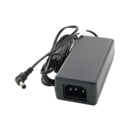 An angled high-angle product photograph of the Datalogic Power Adapter for Magellan 3450VSi / 3550HSi - 12V - 18W - 90ACC0358 is shown against a plain white background. The black rectangular brick unit is in the foreground, angled to the right, prominently displaying its female three-prong C14 AC power inlet on the front face. Behind it and to the left, the black DC output cord is bundled together, leading to the small right-angle barrel connector plug with its standard cylindrical tip.