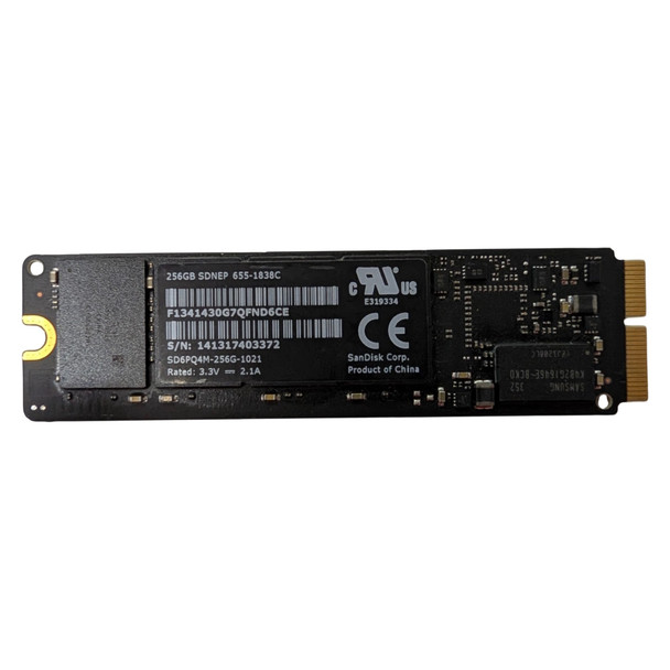 Top label side of the SanDisk X300s 256GB M.2 SATA SSD, displaying the black product label with barcodes, part number SD6PQ4M-256G-1021, technical ratings, regulatory logos, and gold interface pins on the right.