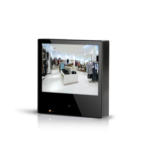 Front view of the Clinton Electronics 8-inch Public View Monitor showing its compact black housing, 8-inch display panel showing a retail store interior feed, and an indicator light on the lower bezel.