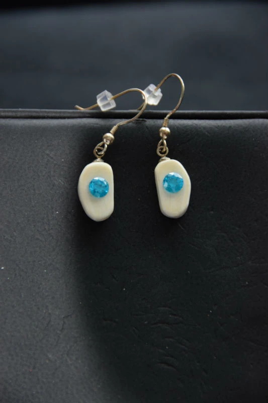 Alaskan Native crafted ivory with a lab-created, round shaped, beautifully faceted teal blue diamond as center stones of this unique earring set