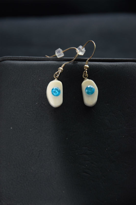 Alaskan Native crafted ivory with a lab-created, round shaped, beautifully faceted teal blue diamond as center stones of this unique earring set