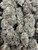 Iceberg Slim is a premium top-shelf cultivar known for its dense, resin-rich buds coated in a thick layer of sparkling trichomes. Deep emerald-green flowers accented by dark purple hues and vibrant orange pistils create exceptional bag appeal, giving each nug a frosty, luxurious finish. Its terpene profile delivers a bold blend of sweet citrus, earthy pine, and gassy diesel with subtle herbal undertones for a smooth, flavorful smoke. Iceberg Slim offers a balanced, long-lasting experience that begins with an uplifting cerebral buzz before settling into a soothing body relaxation, making it an excellent choice for any time of day when you're looking to stay elevated, relaxed, and inspired.