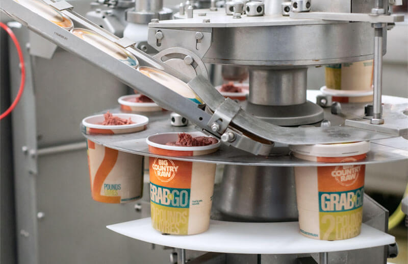 Photo montrant des machines posant des couvercles sur des conteneurs