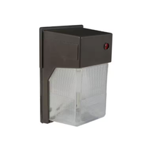 23W Outdoor LED Wall Pack Light in Bronze finish mounted on exterior wall.  LED wall pack light illuminating a commercial parking lot at night.