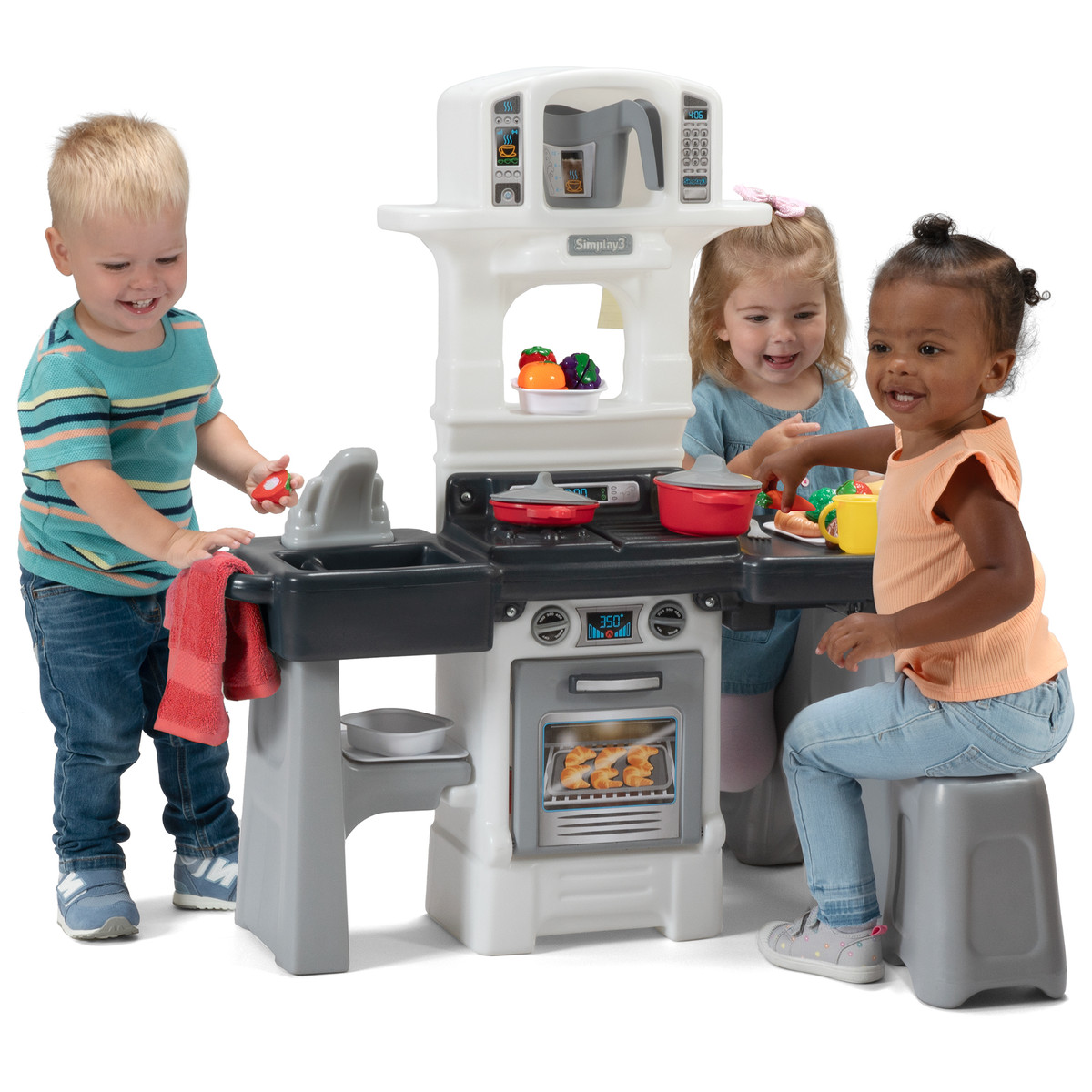 Three children playing happily around the Cooking Kids Dine-In Kitchen