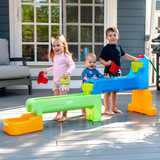 Children playing outside around Simplay3 Rushing River Falls Water Play Table