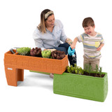 Child watering vegetable garden planted in Simplay3 raised planter for kids 