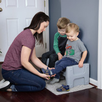 Simplay3 Sibling Step Stool used as a seat for putting on children's shoes.