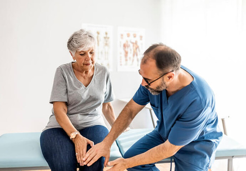 Doctor helping old lady with joints