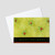 Holiday greeting card featuring a green background with graphical designs of holly berries and a happy holidays message