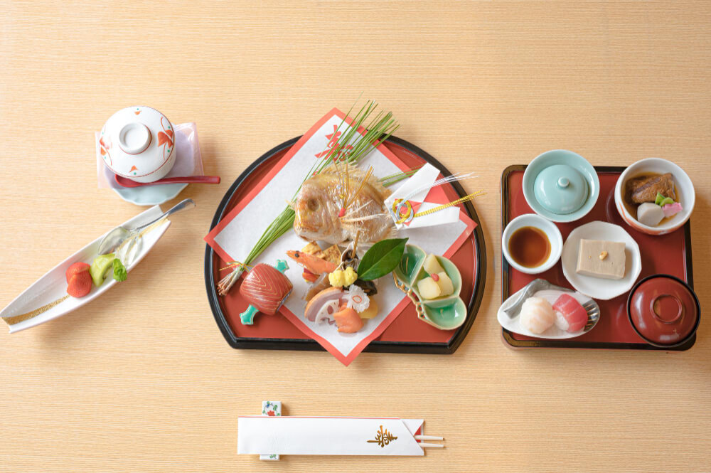 Traditional Japanese Kaiseki dining set with assorted dishes, sushi, and porcelain tableware on a wooden table