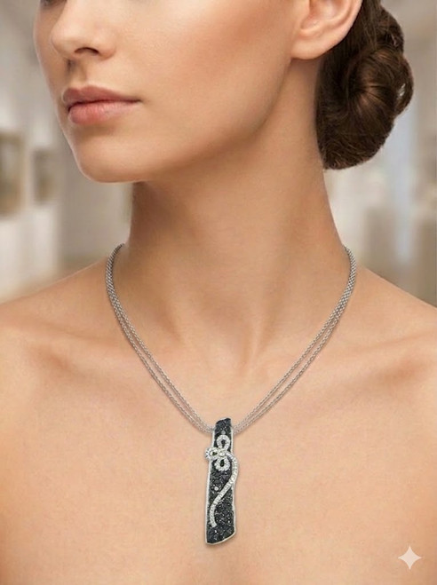 Vertical black diamond bar pendant with white diamond floral vine on a white background.