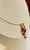side view of 14K gold necklace with cascading amethyst gemstones