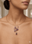 close-up of purple amethyst stones set in 14K gold pendant necklace on model