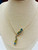 side angle of artistic 14K gold necklace with blue topaz and diamonds