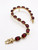 close-up garnet and moonstone gemstones in gold bracelet