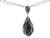 Close-up detail of paving black and white diamonds on white gold pendant.
