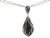 Close-up detail of paving black and white diamonds on white gold pendant.