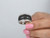 Front-facing view of a wide 14K white gold pavé ring featuring a center section of black diamonds bordered by white diamonds on a clean white background.