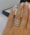 Luxury fine jewelry model wearing the Effy 14k three-tone gold overlapping diamond ribbon ring on a manicured hand