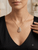Close-up of EFFY tri-color gold diamond leaf pendant necklace worn by a model