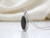 Angled view of EFFY 14K white gold oval black and white diamond halo pendant with chain