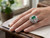 EFFY emerald and diamond swirl halo ring worn on a model’s hand