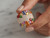 Close-up of model's fingers holding EFFY 14K rose gold multi-color gemstone and diamond ring
