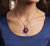 Elegant model wearing EFFY 14K rose gold amethyst and rhodolite flower pendant necklace with silk blouse