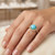 Model wearing 14K yellow gold EFFY turquoise and diamond halo ring on hand