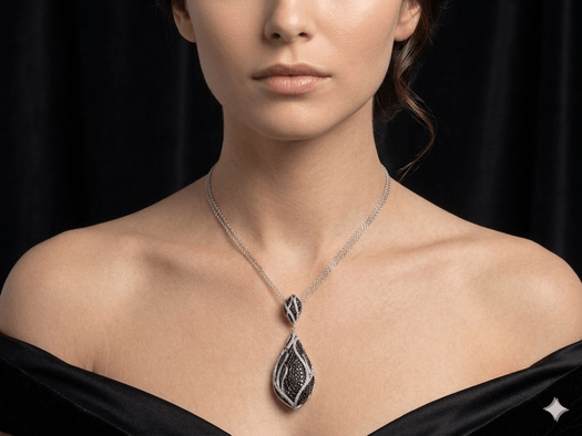 Model wearing teardrop pendant with black and white diamonds and gray dress.