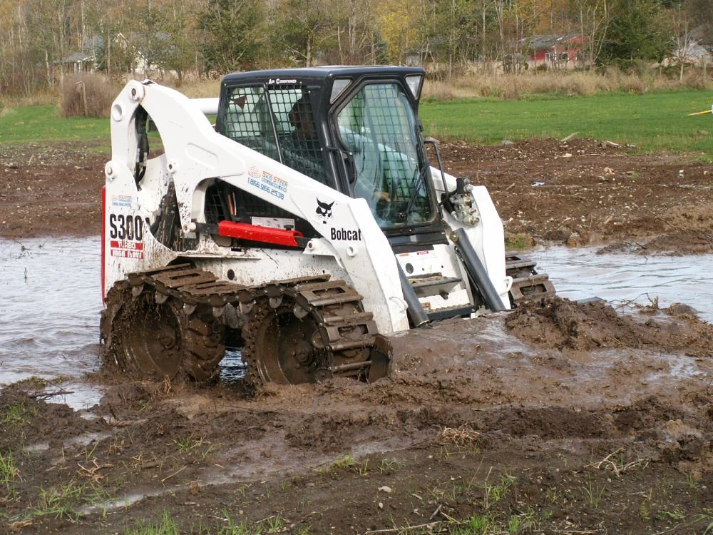 Bobcat driving through mud