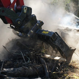 Raking debris with the excavator root rake.