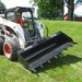 Bradco Skid Steer Power Tilt Tach angled view, tilting a bucket attachment