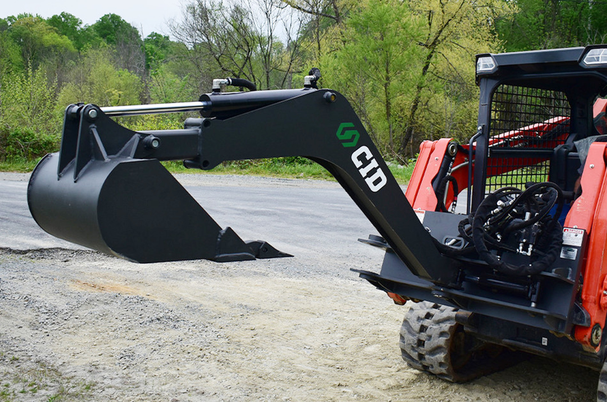 Skid Steer Swing Arm Backhoe Attachment front angled view of a skid steer with a cid skid steer swing arm backhoe attachment on the front tilted down