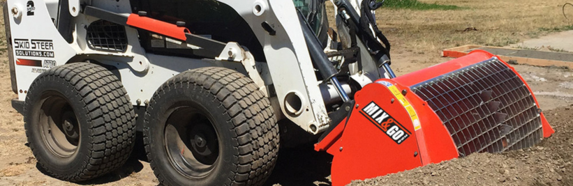 left angled view of a skid steer parked on dirt with an eterr mix and go concrete mixer attachment on the front