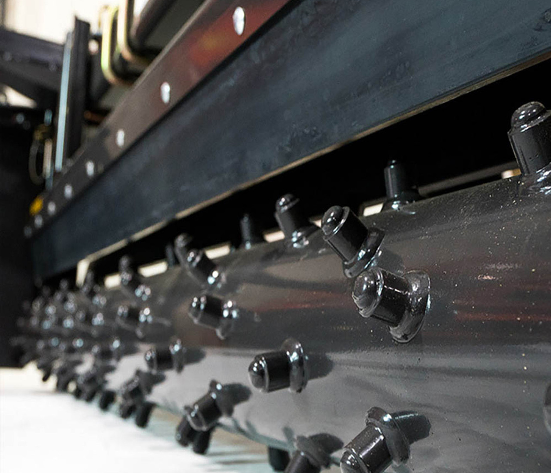 right-angled closeup view of the roller on a paladin skid steer harley rake attachment