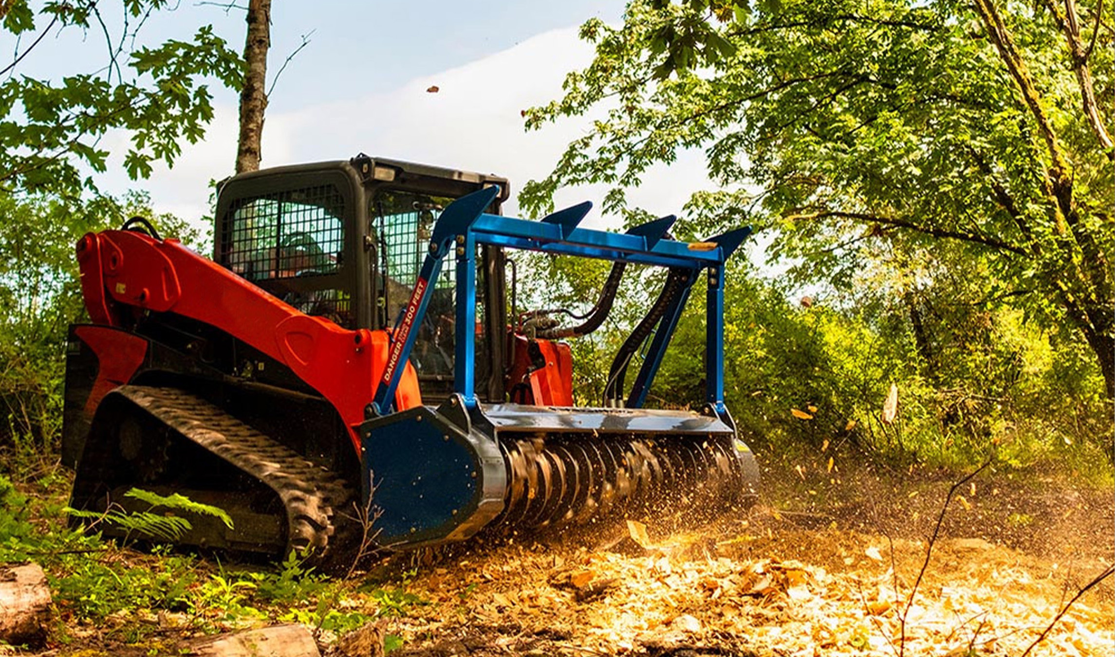 Skid Steer Forestry Mulcher Attachment left angled view of a skid steer parked on dirt with a promac forestry mulcher attachment on the front