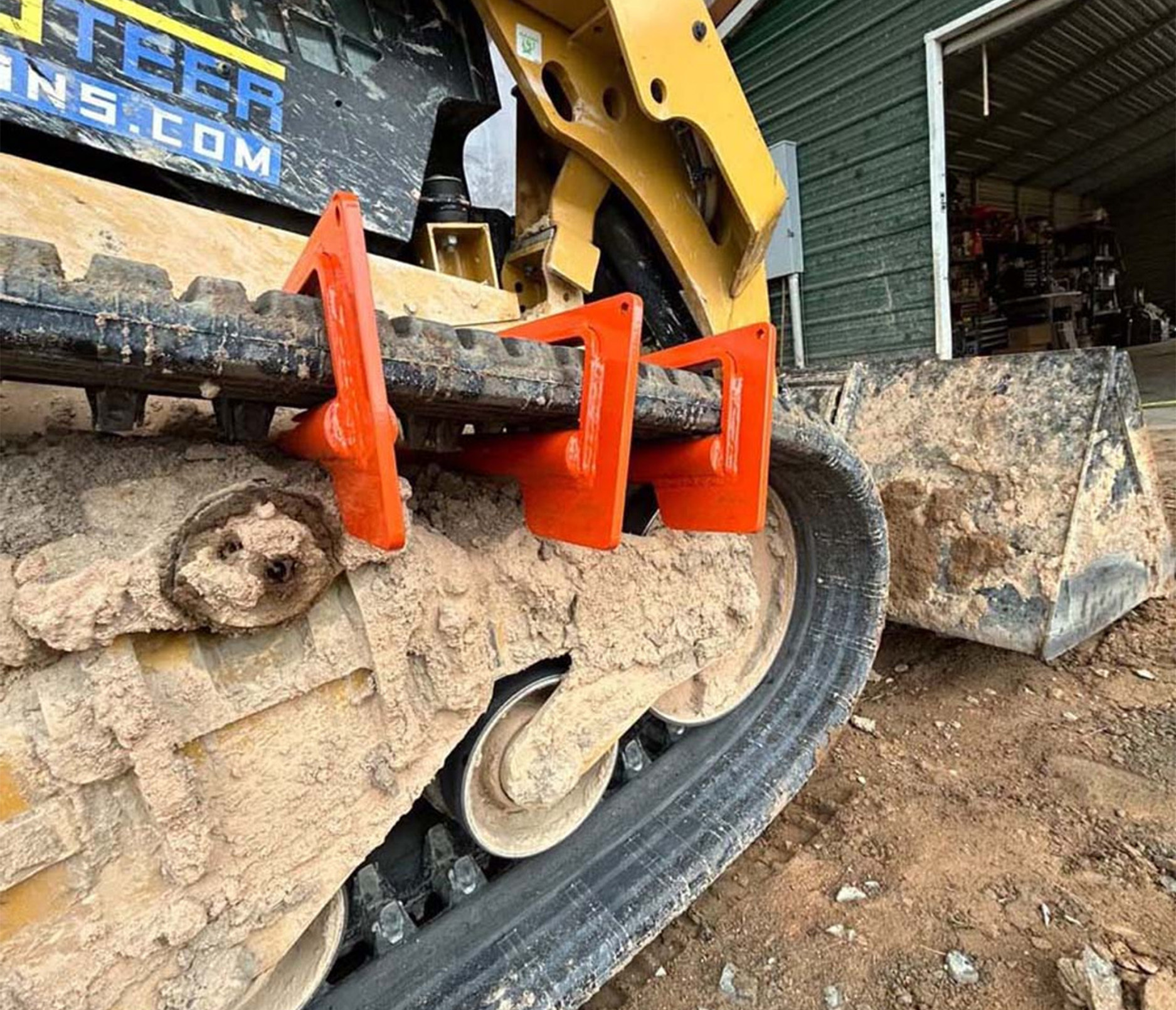 closeup view of a skid steer track with a track bar repair tool on it 