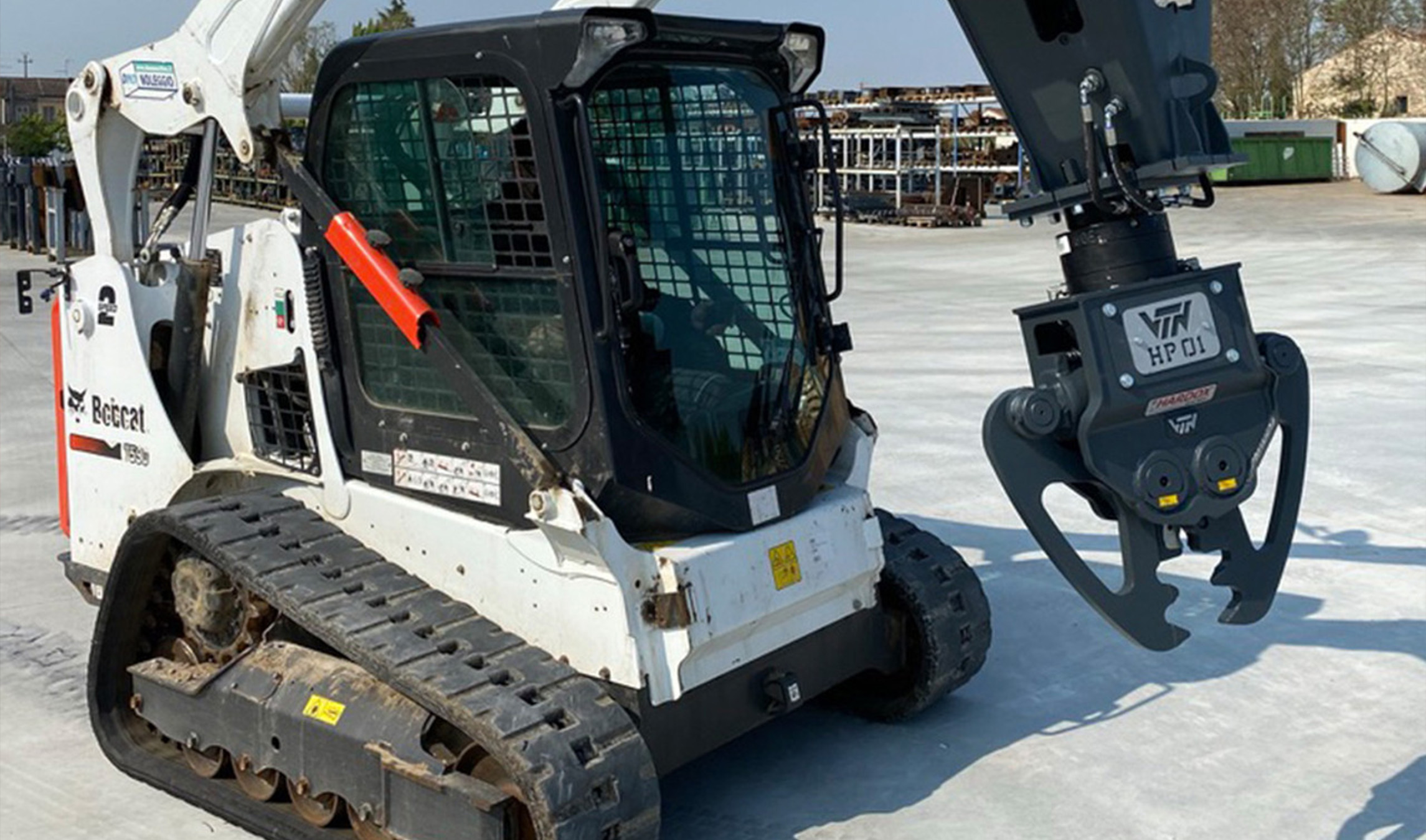 Skid Steer Concrete Breaker front right side angle view of a skid steer parked on concrete with the VTN concrete cracker attached and aimed down