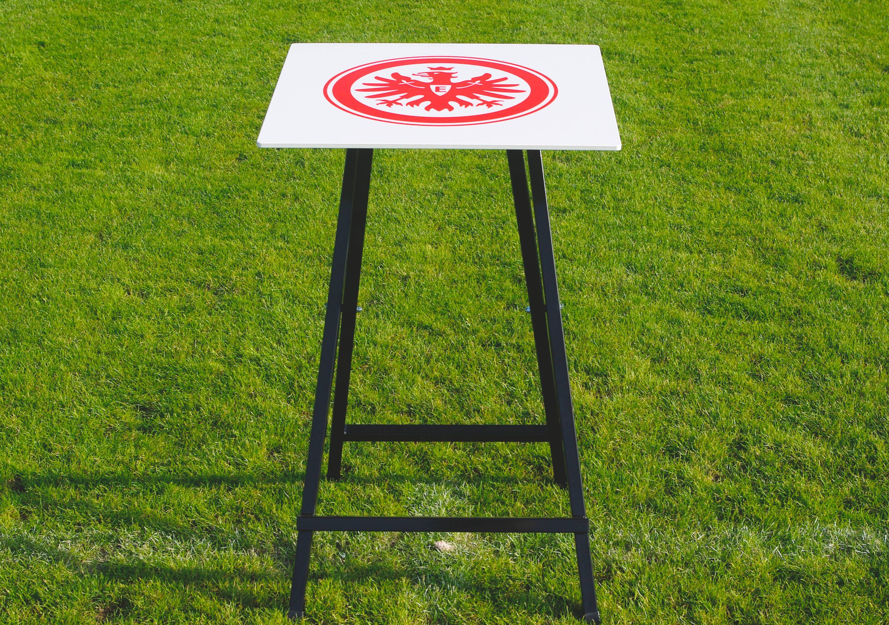 Stehtisch mit Eintracht-Frankfurt-Logo auf grünem Rasen