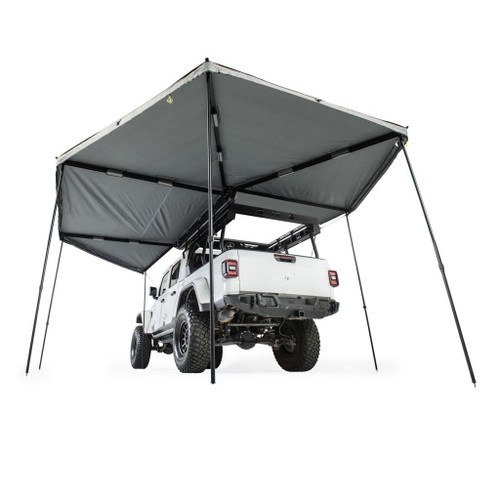 Jeep equipped with a Smittybilt 270 Degree Awning and a tent mounted on top, ready for outdoor adventures.