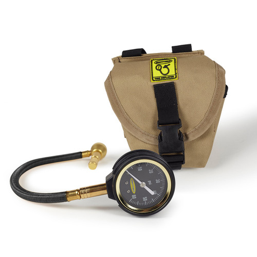 A pressure gauge alongside a bag and hose featuring the Smittybilt R.A.D Rapid Air Deflator for efficient tire deflation.