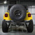 The yellow jeep's back end displays a Smittybilt Gen 2 SRC rear bumper and a tire mounted on it.
