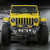 Yellow Jeep showcasing a Smittybilt Gen2 XRC front bumper positioned inside a garage.