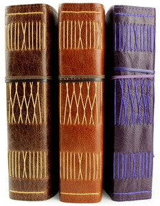 Majestic sized A5 leather journals. Hand stitched and handcrafted in Australia. The leathers featured here are: Antique Oak, Cognac and Violet Purple.