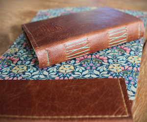 Cognac brown leather handstitched leather A6 journal.  Lined with Persephone Sage Liberty of London print.