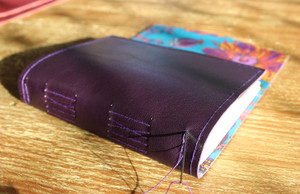 Purple leather handstitched A6 journal. Lined with Fantasy Land Liberty of London Fabric.